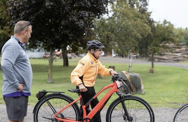 A cyclist in a yellow jacket and helmet with his bicycle at the Big Move Cancer Ride