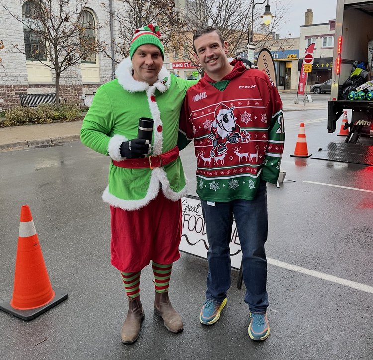 Matt Harris with a volunteer in an elf costume at the Great Holiday Food Drive at Market Square