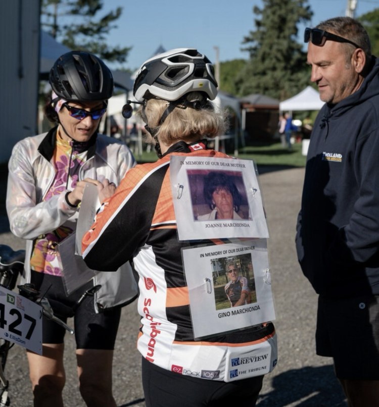 A rider at the Big Move Cancer Ride wearing memorial photographs of Joanne and Gino Marchionda on her jersey
